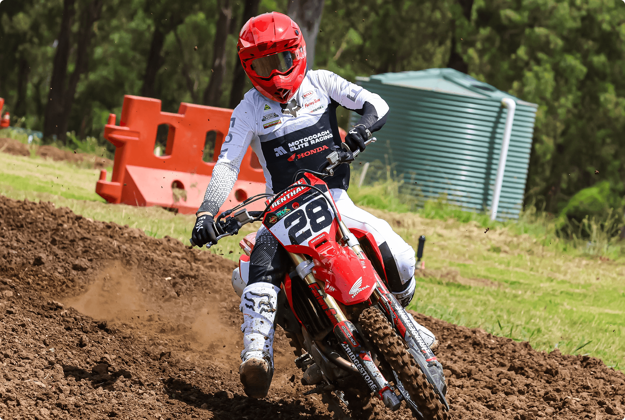 Motocoach Elite Racing rider number 28 cornering a Honda on a dirt track
