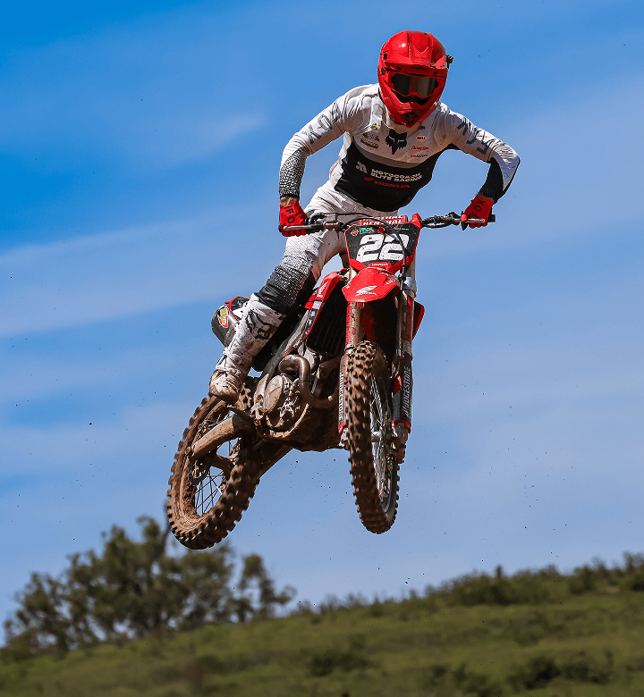 Motocoach Elite Racing rider in the air over a motocross jump, number 22