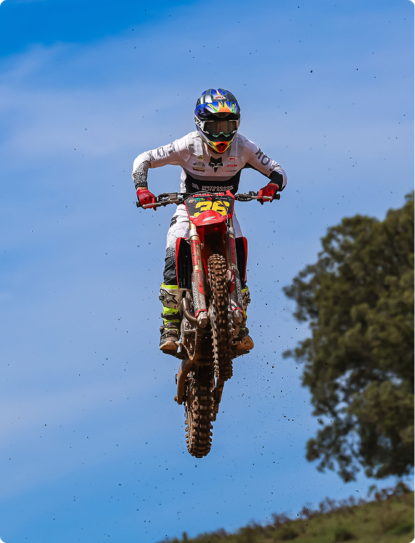 Motocross rider in the air, front-on, against a blue sky